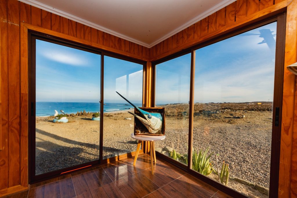 Ventanal de una cabaña con vista a la playa de Punta de Choros