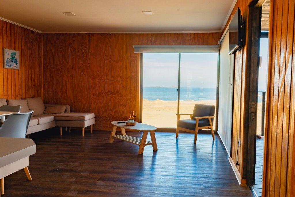 Estar de una cabaña con sillones y vista al mar