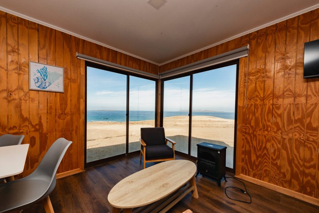 Comedor de una cabaña con ventana al mar