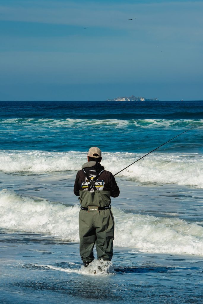 Pesca de orilla entre las olas